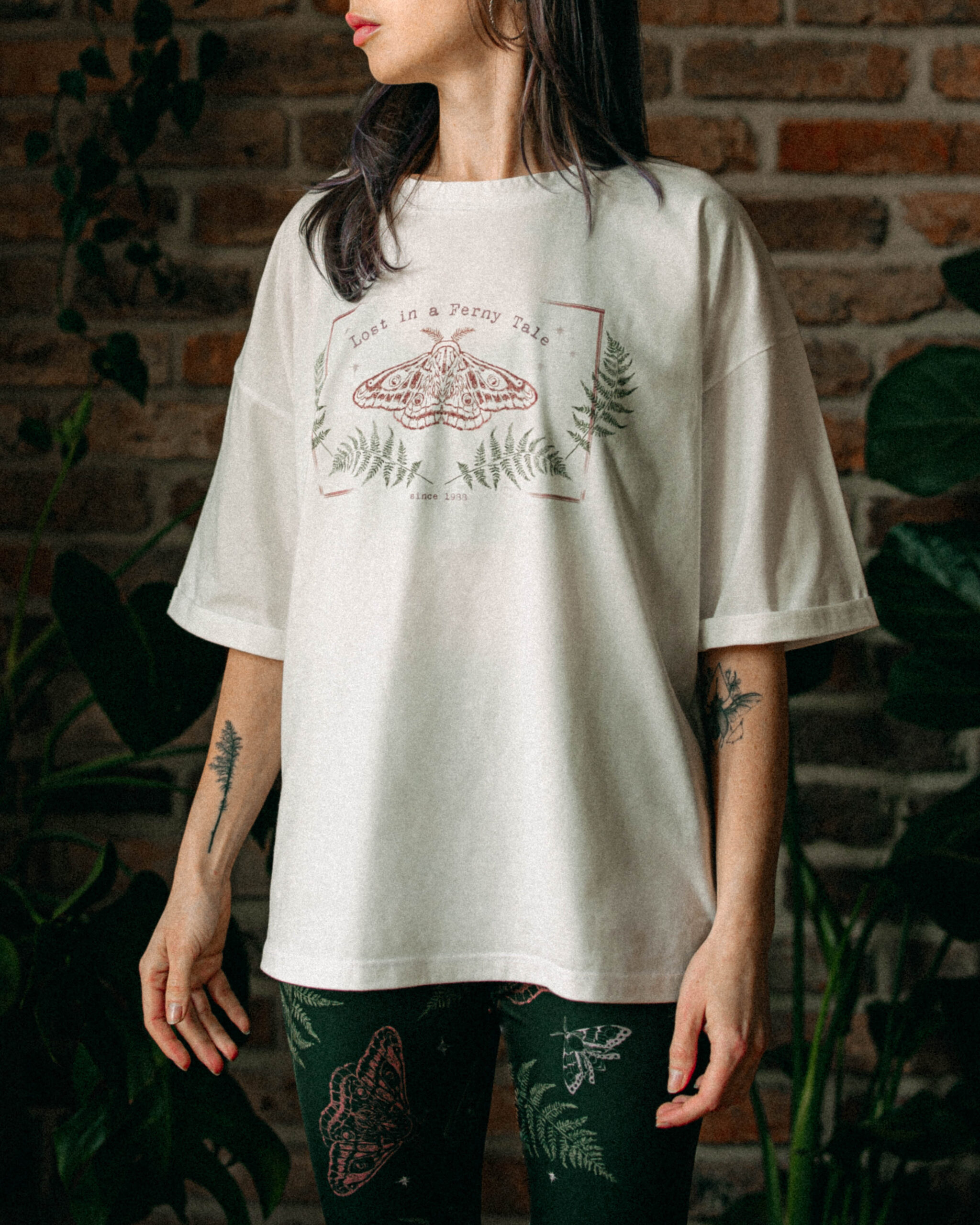 Woman wearing an oversized cream-colored t-shirt with a soft printed design.