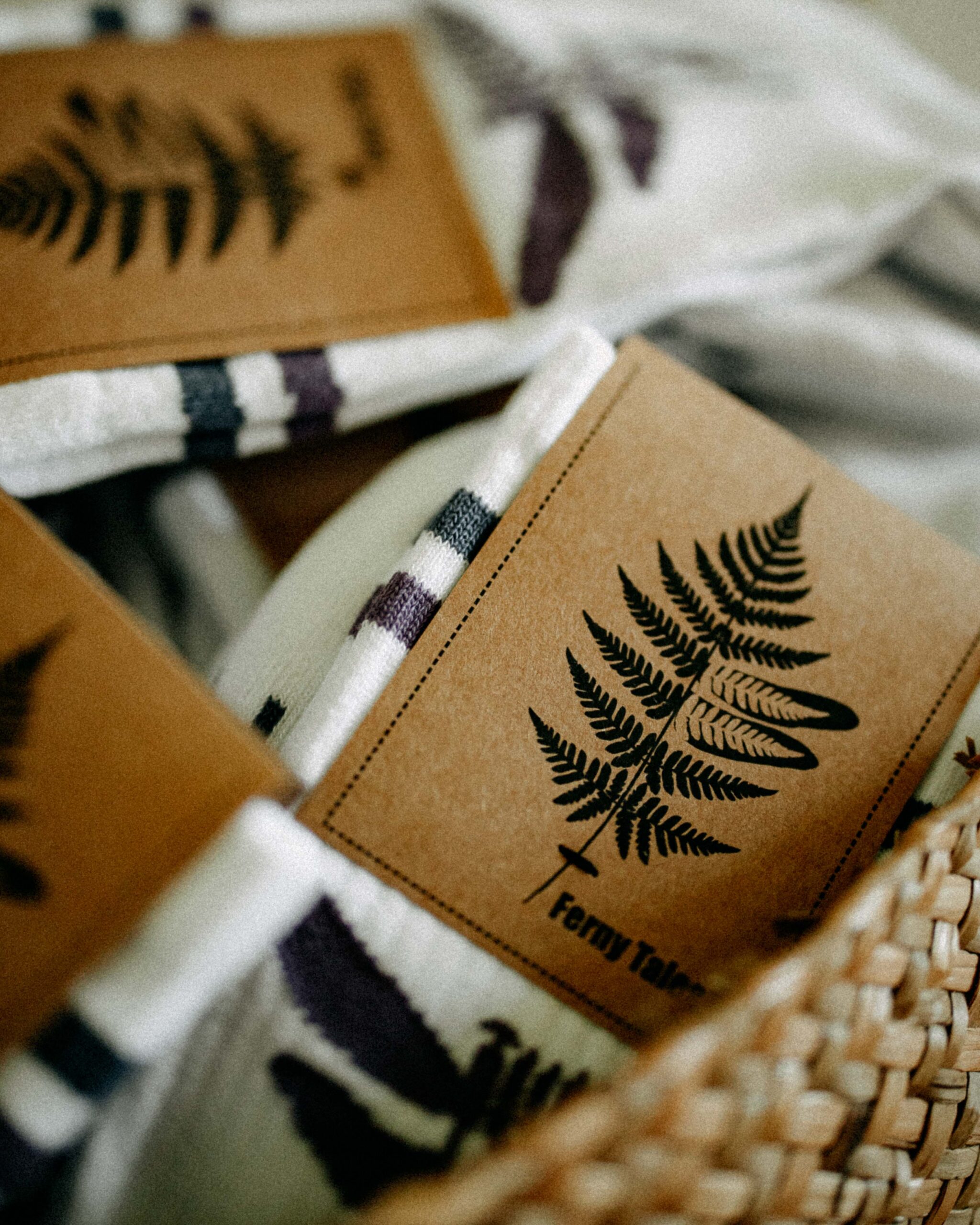 Close-up of Ferny Socks in kraft paper packaging with fern design.