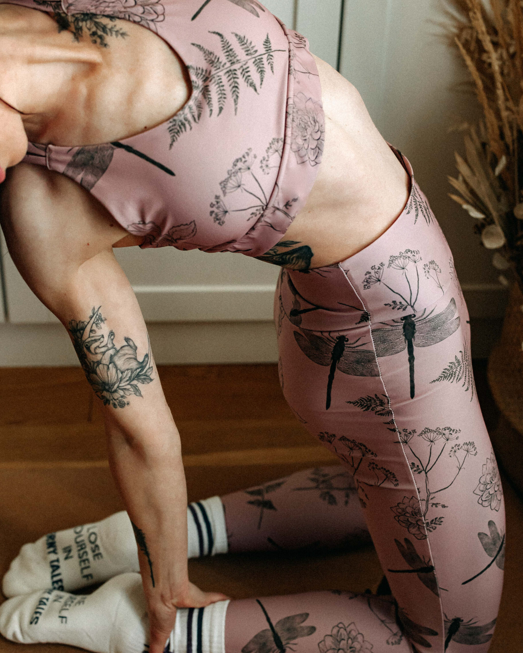 Model streaching, wearing the sport top with matching leggings.